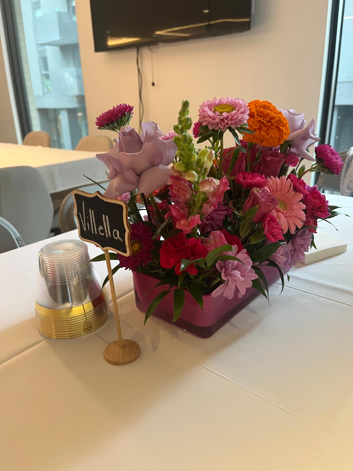 Close up of a colorful custom floral arrangement in a rectangular vase designed for an event in North York